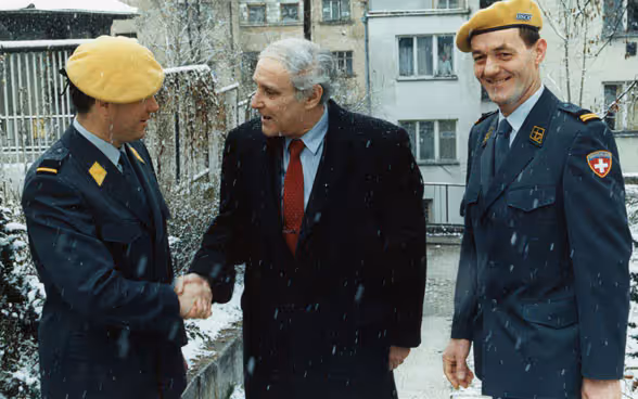 FDFA head and OSCE chairperson-in-office Flavio Cotti speaking with members of the Swiss Yellow Berets in 1996.