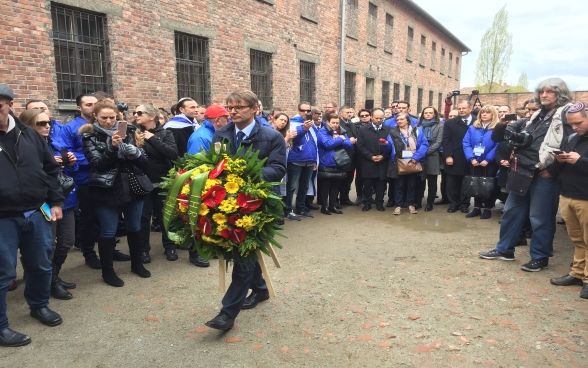 Benno Bättig, Chair of the International Holocaust Remembrance Alliance (IHRA), lays a wreath at the Death Wall in Auschwitz during the March of the Living on 24 April 2017.