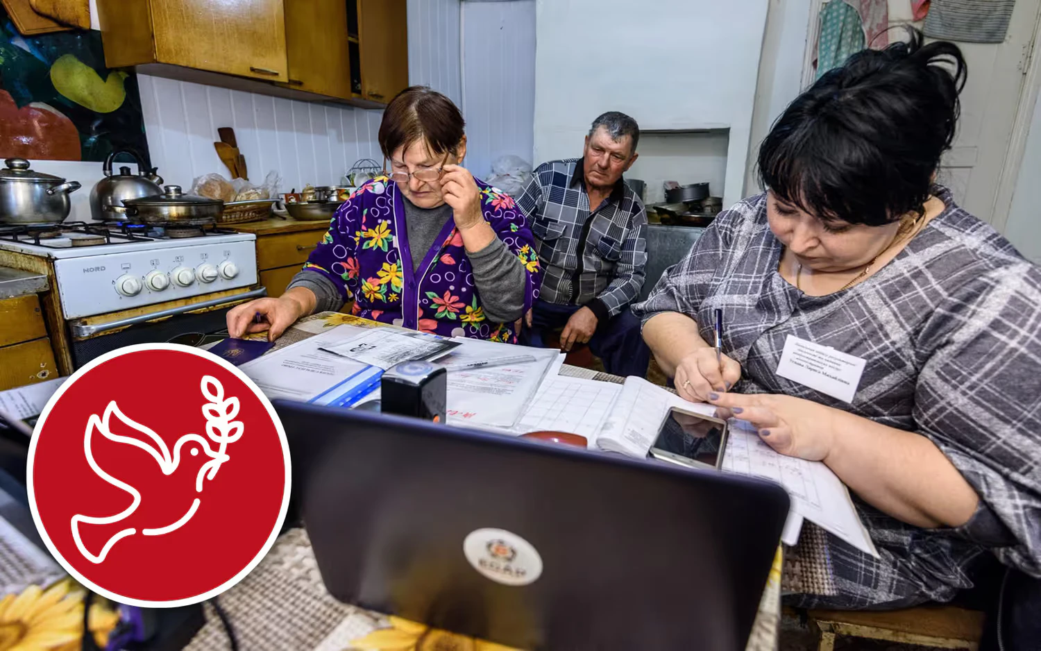 Two women fill out voting documents on a computer