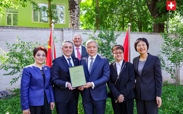 Federal Councillor Ignazio Cassis, Swiss Ambassador to China Jürg Burri and the Chinese delegation pose in the garden of the Swiss embassy in Beijing. 