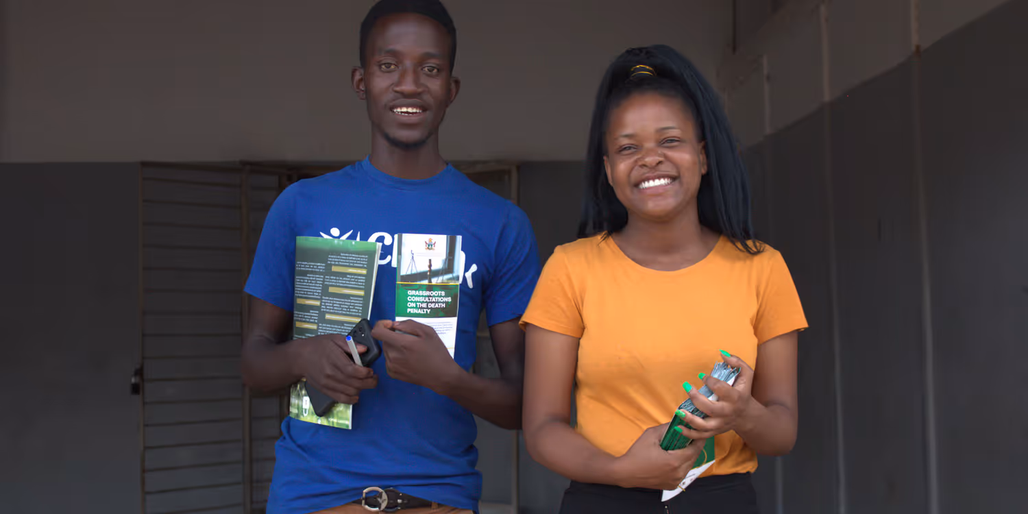 A man and a woman are holding brochures.