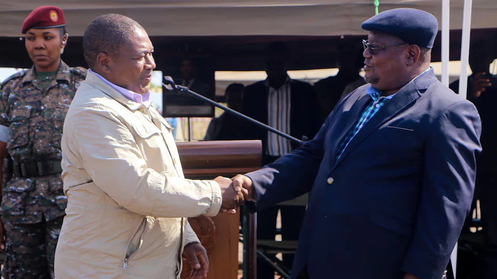 The president of the RENAMO movement and the president of Mozambique shake hands.