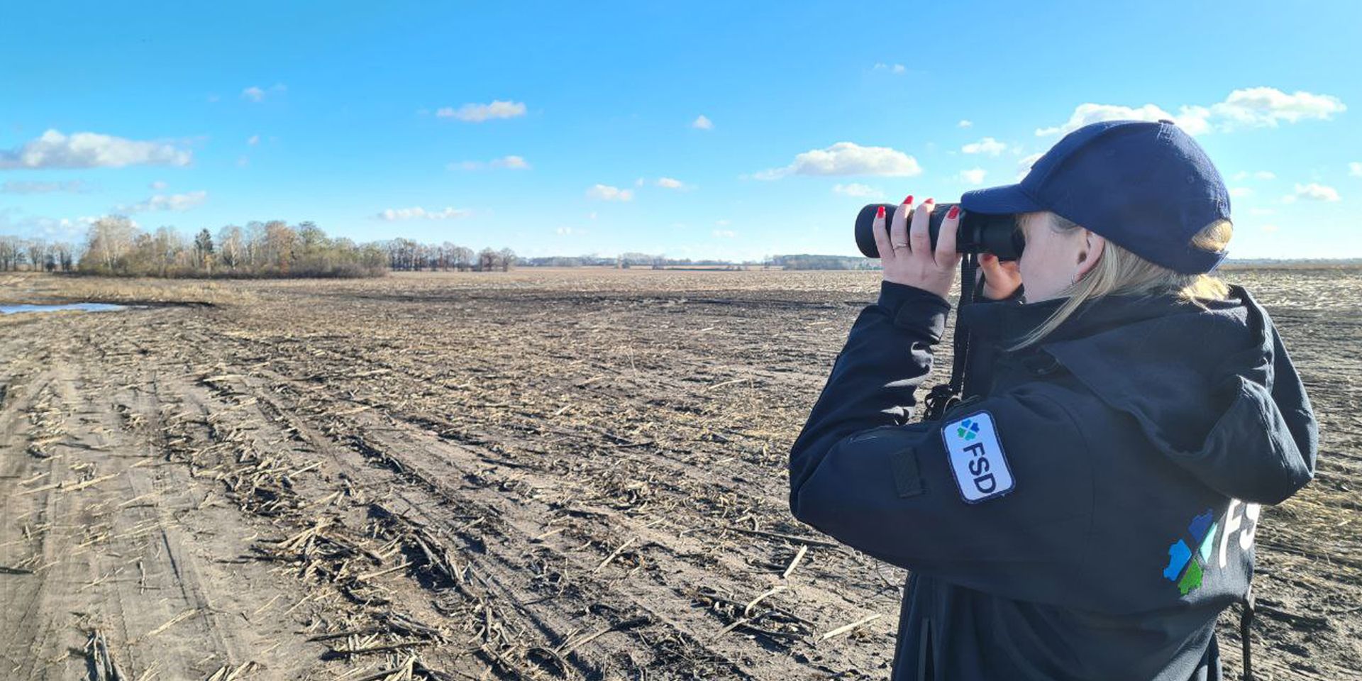FSD non-technical survey operator surveying land with binoculars.