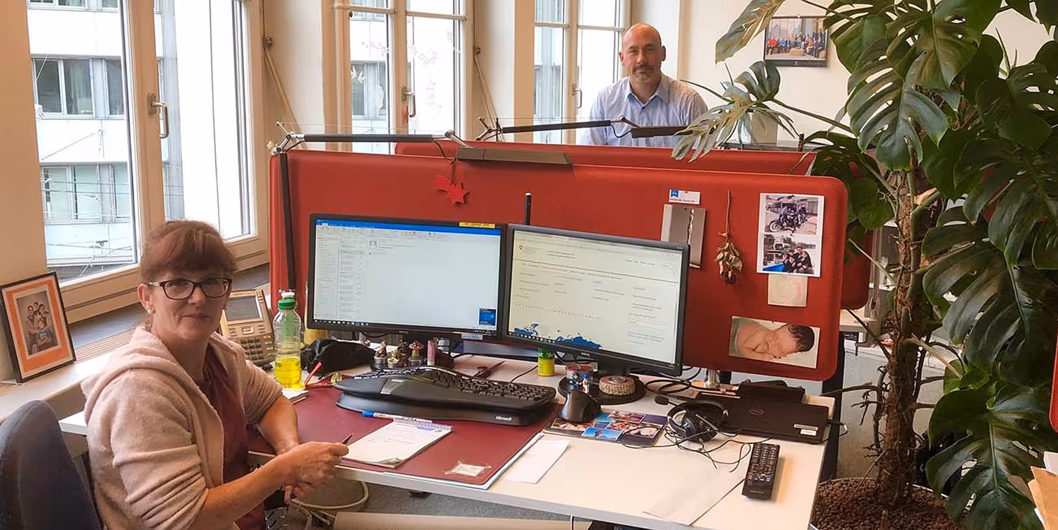 The FDFA Helpline in action. Photo of two members of the Helpdesk team in their office in Bern. 