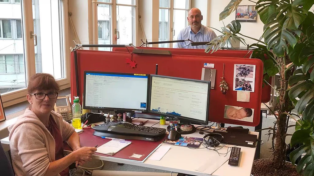 The FDFA Helpline in action. Photo of two members of the Helpdesk team in their office in Bern. 