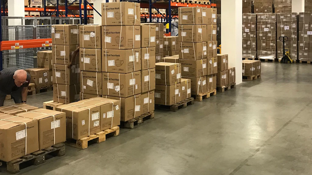 Vue du dépôt d'aide humanitaire avec des cartons empilés sur des palettes de transport.