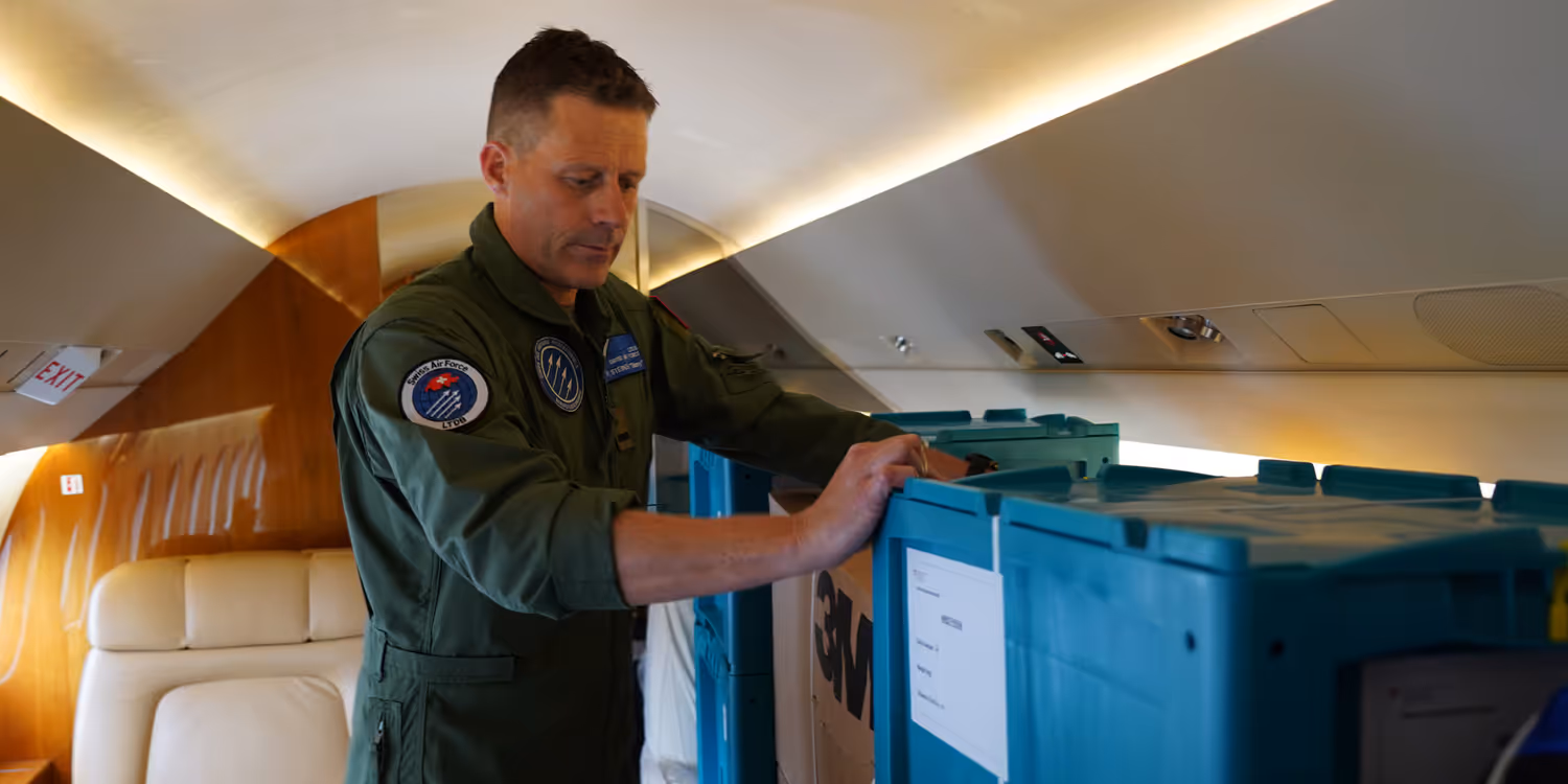 Un pilote vérifie l’arrimage des caisses contenant le matériel de secours à l’intérieur de l’avion.