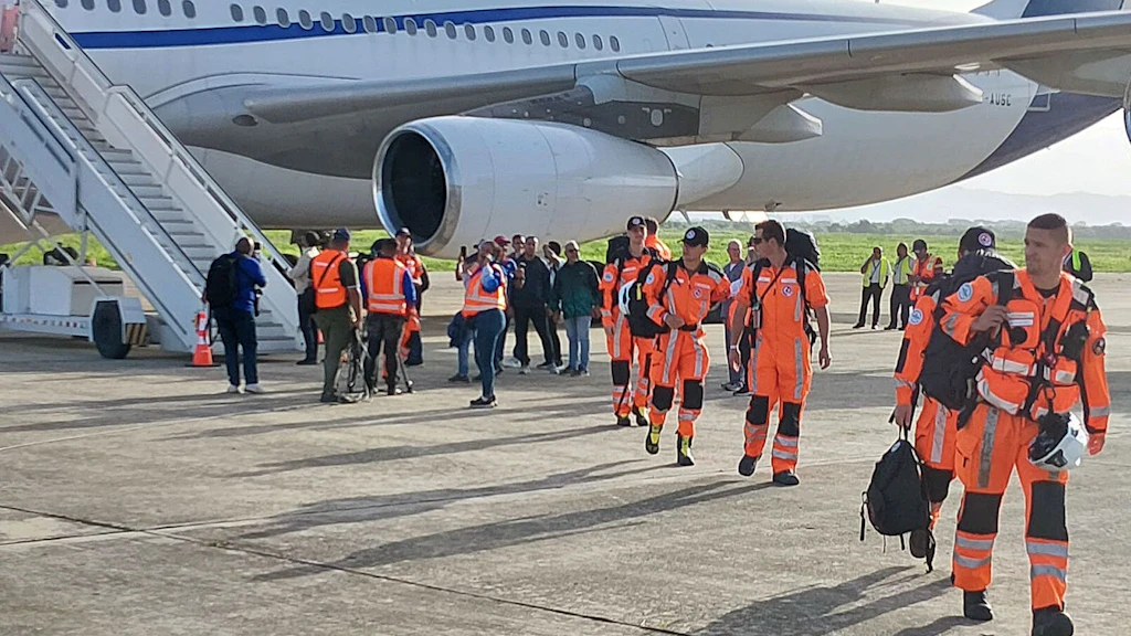 Les membres de la chaîne de sauvetage descendent d'un avion.