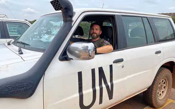 Un policier de l’ONU au volant d’une voiture blanche siglée «UN».