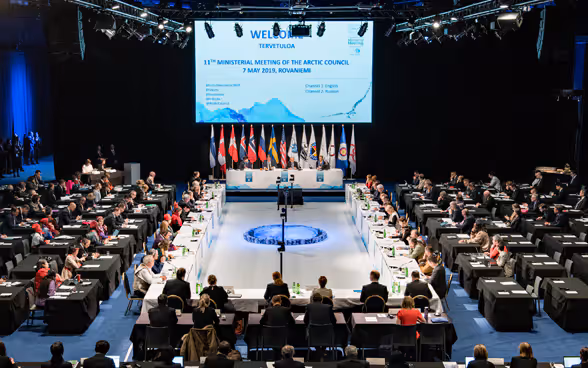 Les membres du Conseil de l'Arctique sont assis dans une grande salle.