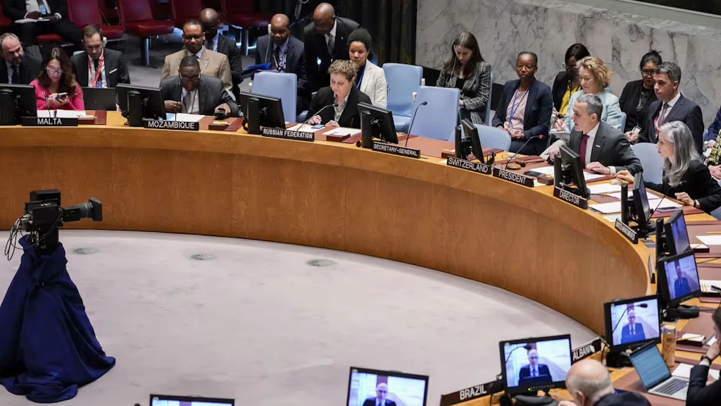 Des hommes et des femmes sont assis à la table en fer à cheval du Conseil de sécurité de l'ONU et écoutent les explications du conseiller fédéral Ignazio Cassis.
