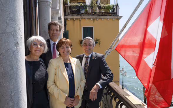 Photo du conseiller fédéral Ignazio Cassis aux côtés de la conseillère fédérale Elisabeth Baum-Schneider, de l’ambassadeur Roberto Balzaretti et de la conseillère d’État Marina Carobbio sur le balcon du Palazzo Trevisan.