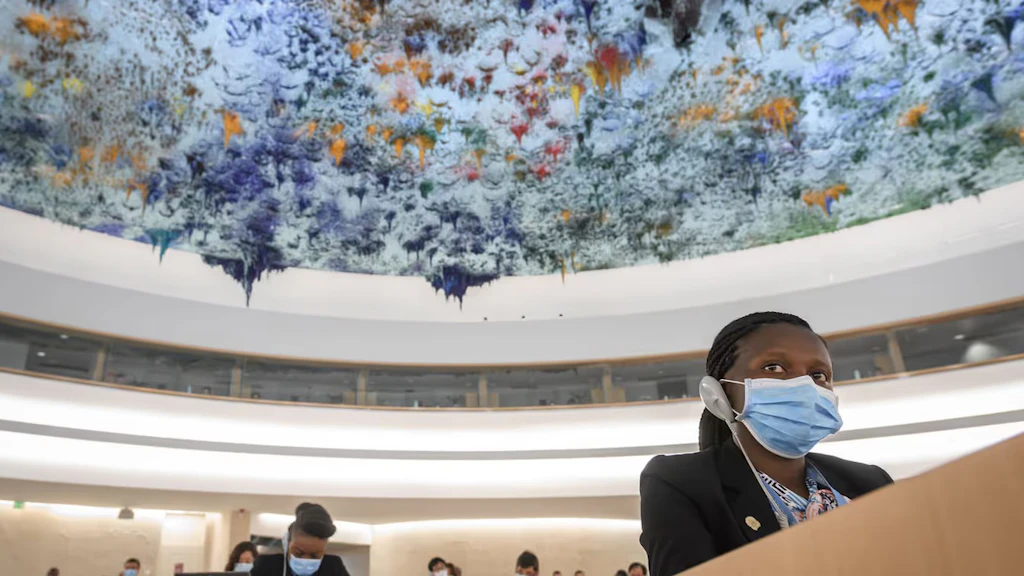 Une femme utilise un appareil de traduction pour écouter un orateur pendant la session du Conseil des droits de l'homme des Nations unies. 