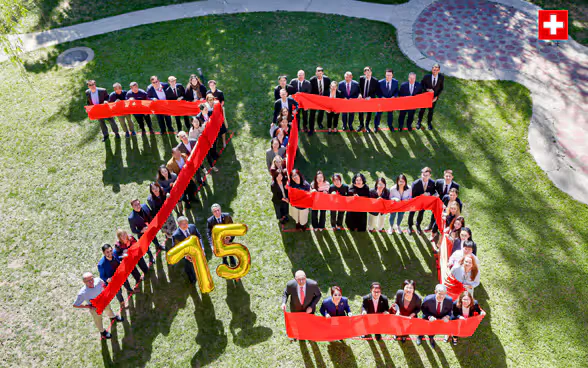 Les collaborateurs de l'ambassade de Suisse à Pékin forment le chiffre 75 sur une pelouse. 