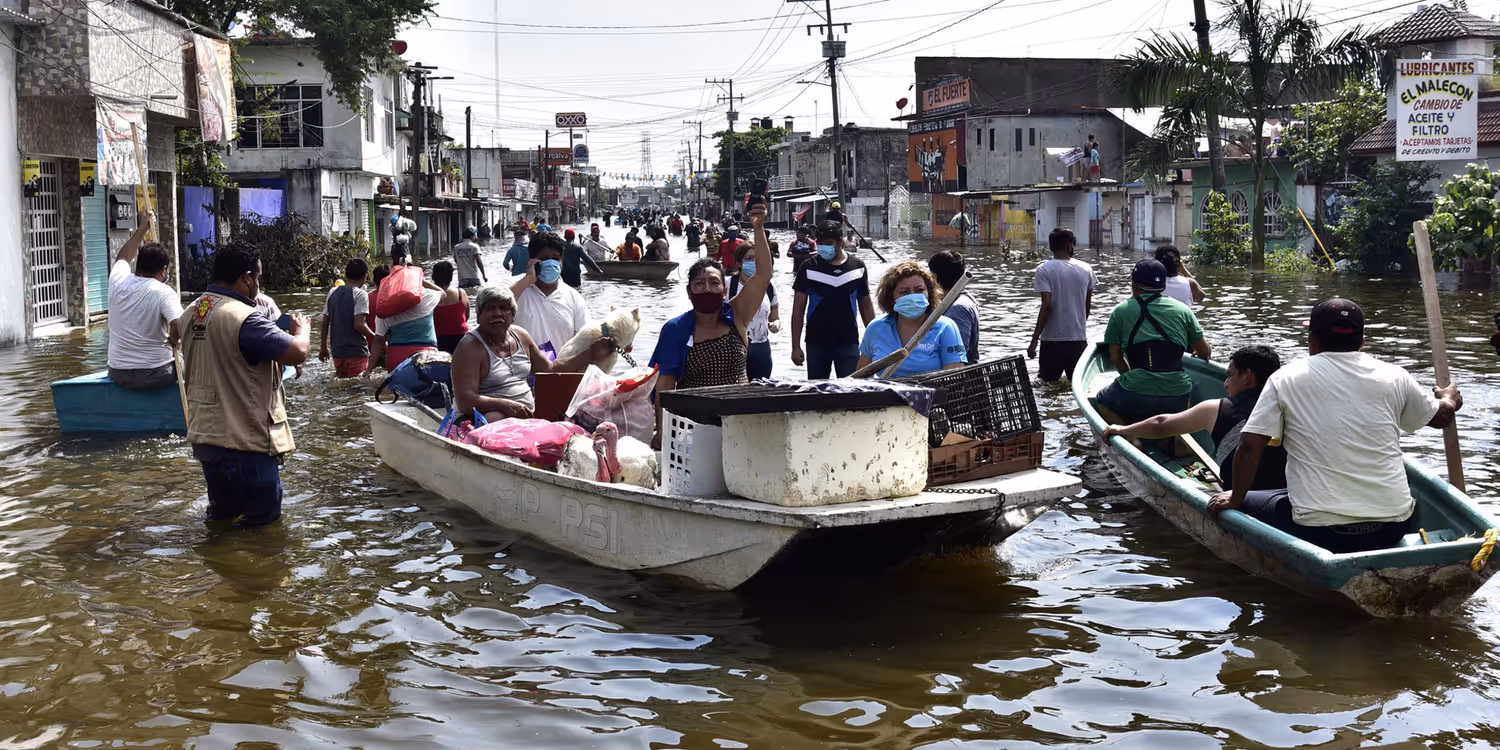Des habitants traversent une avenue inondée par de fortes pluies suite au passage de l’ouragan Eta.
