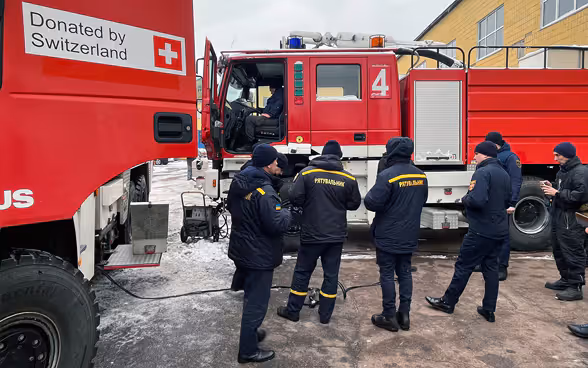 Des hommes de la protection civile ukrainienne sont formés à l'utilisation de véhicules de pompiers offerts par la Suisse.