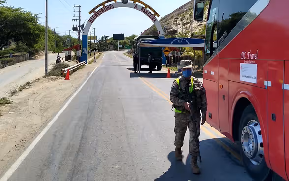 À un point de contrôle, un soldat vérifie si le bus a l'autorisation de passer.