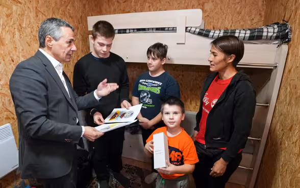 Le président de la Confédération Ignazio Cassis s'entretient avec une famille qui a bénéficié de l'aide suisse en Ukraine.