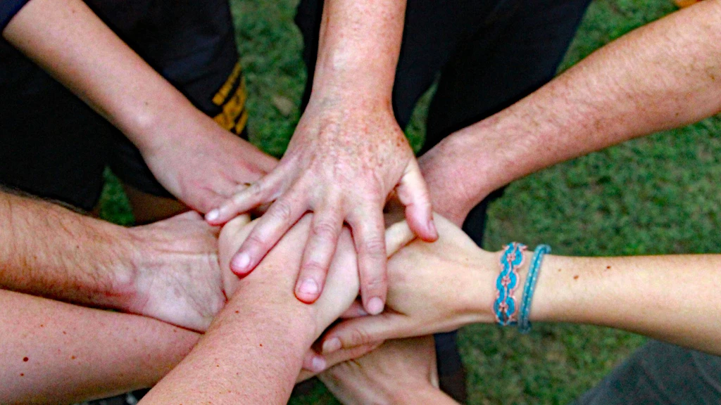 Image représentant des mains jointes qui forment un cercle, symbolisant l’engagement social et la coopération.
