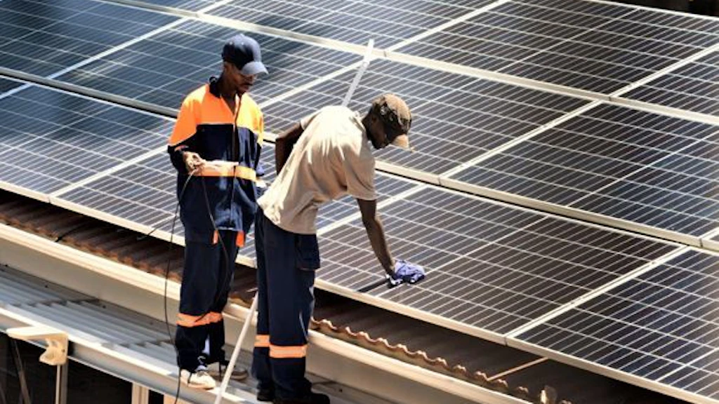 Des prestataires de services locaux installent des panneaux solaires sur les toits de l’Ambassade de Suisse à Harare.
