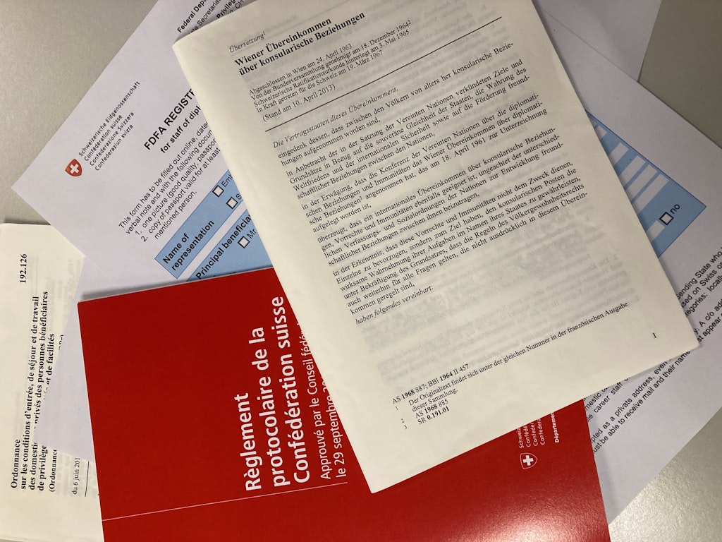 Différents documents, tels que la Convention de Vienne sur les relations consulaires, posés sur une table.