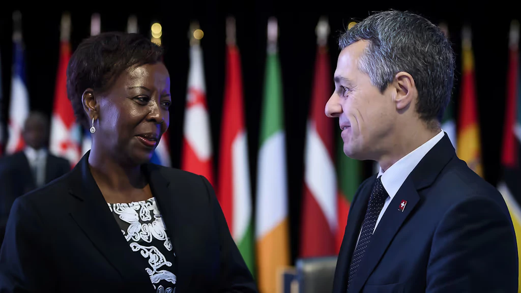 Ignazio Cassis et la secrétaire générale de la Francophonie Louise Mushikiwabo discutent. En arrière-plan, les drapeaux des 88 États et gouvernements membres.