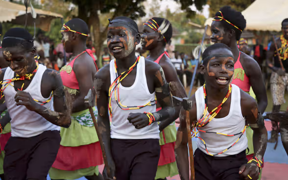 Des enfants africains aux visages peints dansent.