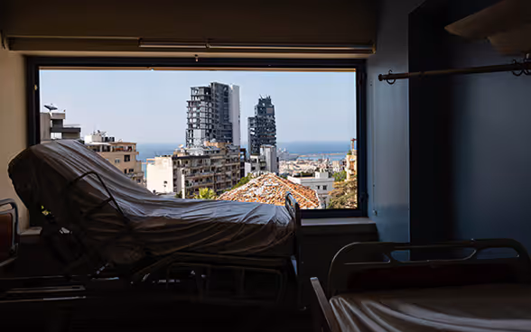 Vue d'un lit de maternité avec vue par la fenêtre sur la capitale détruite du Liban.