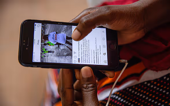 Une personne africaine tient un smartphone dans ses mains