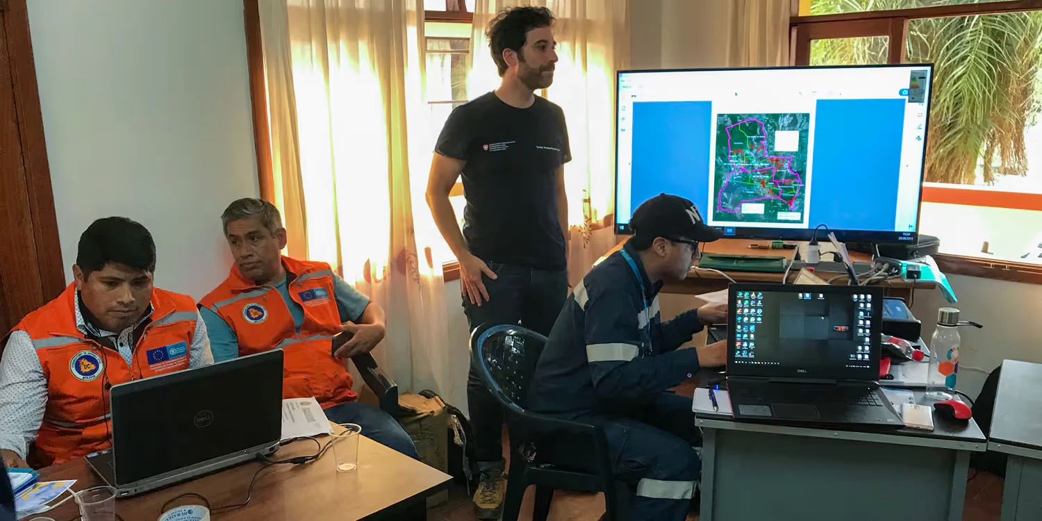 Omar Bellprat se tient devant un grand écran dans une centrale d'intervention où règne une grande animation.