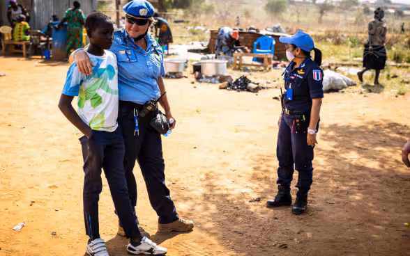 Une policière de la police de l'ONU parle à un garçon africain.