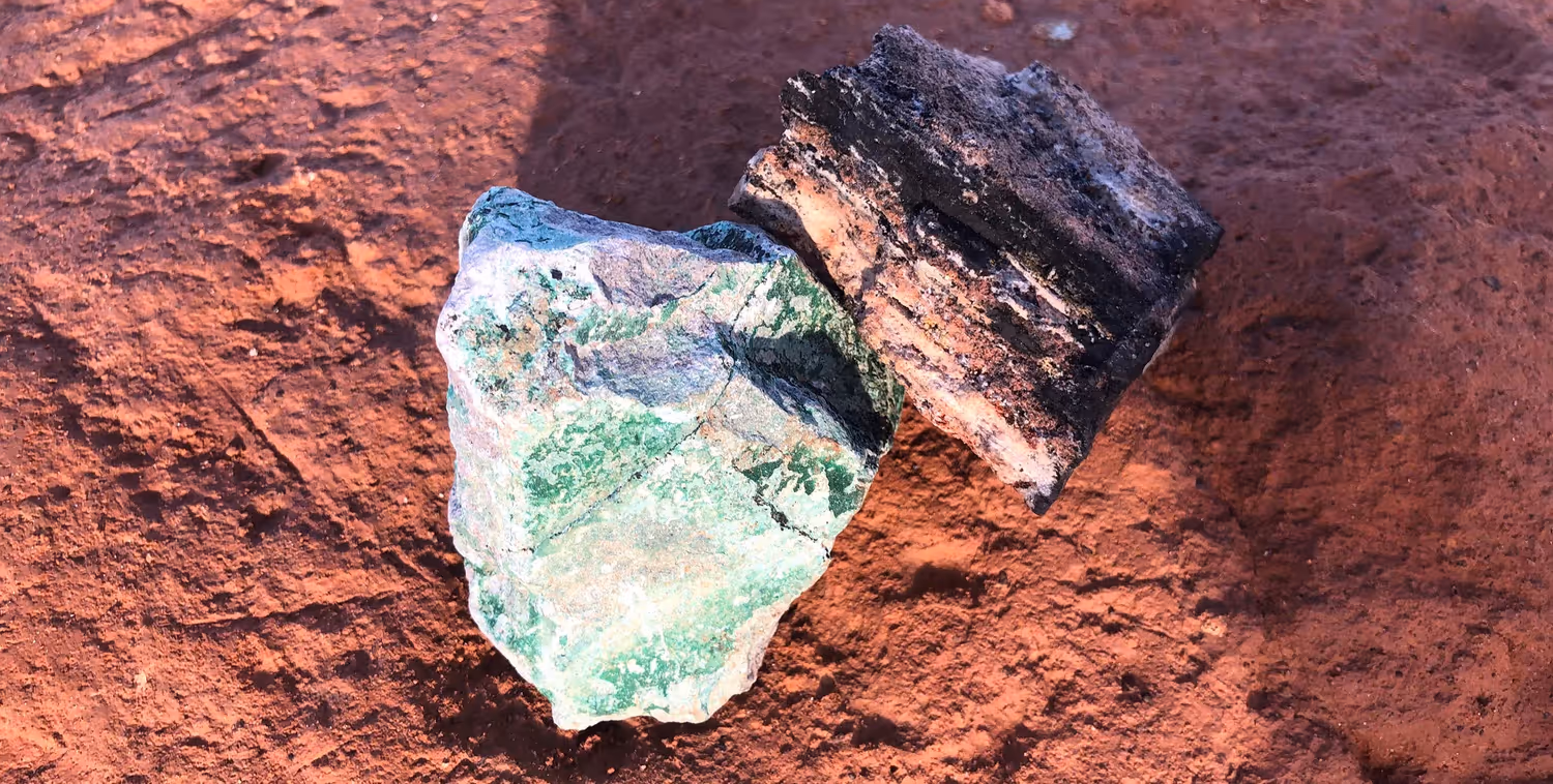 Un pezzo di cobalto, di colore nero, e un pezzo di rame, di colore verde, sono stati posati sul terreno ocra per illustrare l’attività di estrazione mineraria nella regione del Copperbelt, nella Repubblica democratica del Congo.