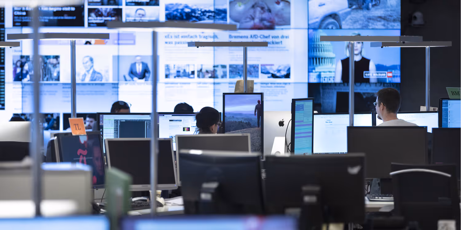 La redazione di un giornale. I giornalisti lavorano davanti a degli schermi.