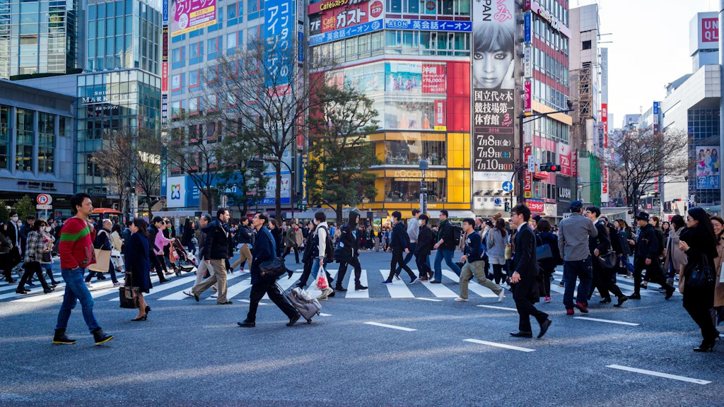 Persone che attraversano un incrocio a Tokyo alla fine della giornata.