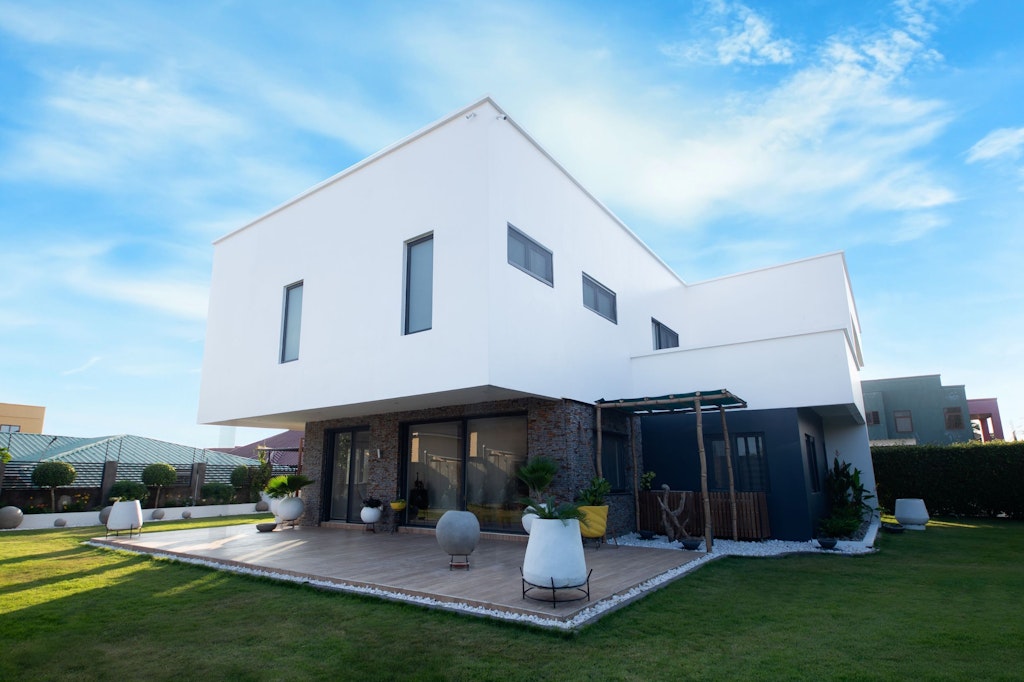 Una casa bianca, moderna, con terrazza e giardino.