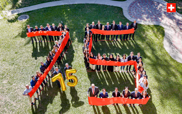  I collaboratori dell'Ambasciata svizzera a Pechino formano il numero 75 su un prato. 