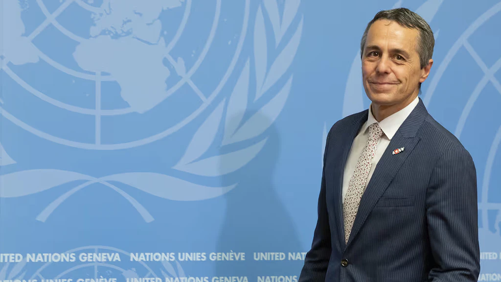 consigliere federale Ignazio Cassis sta davanti a un podio, dietro di lui un muro con il logo dell'ONU.