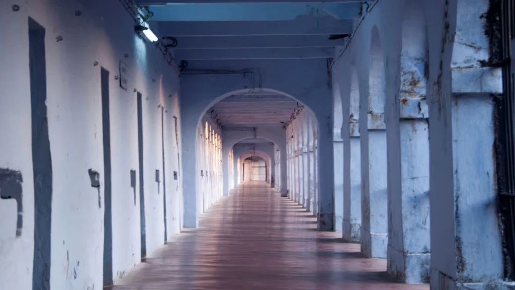Un corridoio bianco con porte di celle in una prigione in India.