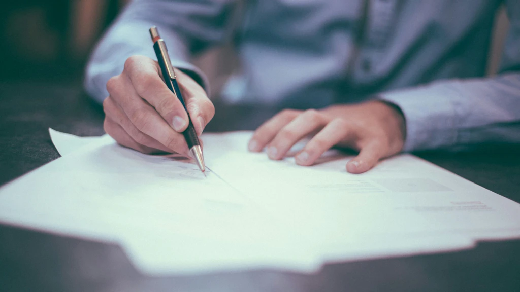 Un uomo firma un documento.