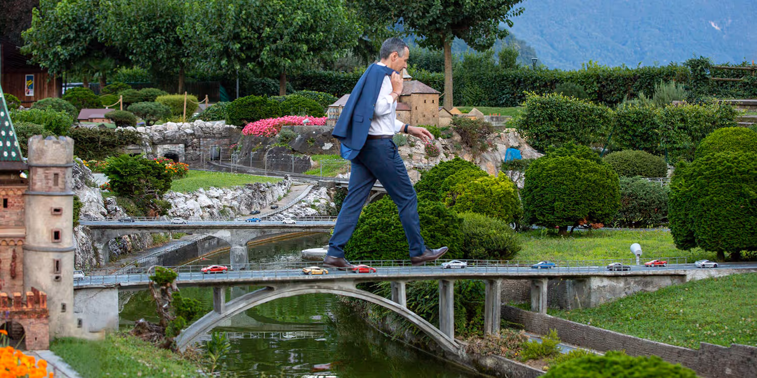 Il consigliere federale Ignazio Cassis mentre attraversa un viadotto autostradale nella Svizzera in miniatura.