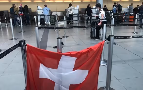 Nella hall dell'aeroporto di Bogotà, una bandiera svizzera è stata appesa al banco del check-in per il volo di rientro in Svizzera.