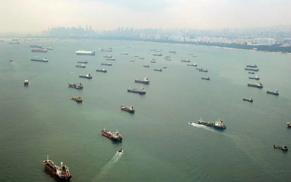 Navi da carico nel porto di Singapore che navigano nella stessa direzione.