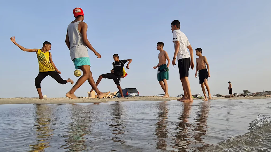 Alcuni giovani giocano a calcio su una spiaggia di Garabulli, a circa 70 km dalla capitale Tripoli.