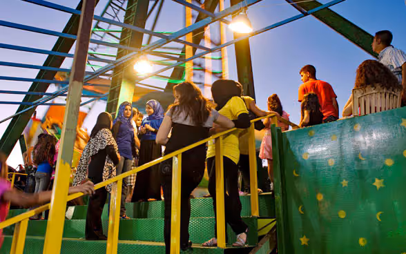 Giovani della regione araba del Mediterraneo in piedi su una scalinata.