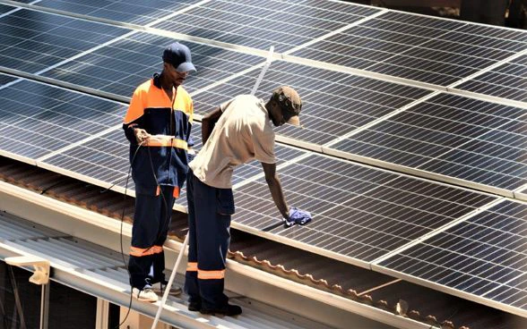 Fornitori di servizi locali installano pannelli solari sul tetto dell’Ambasciata di Svizzera ad Harare.
