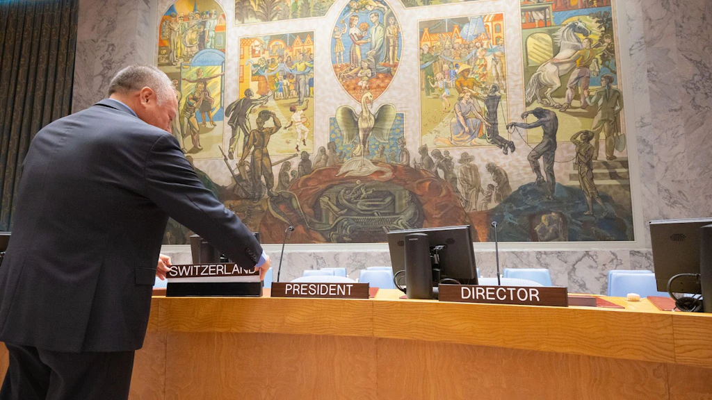  Un funzionario dell’ONU colloca un cartello con la scritta «Svizzera» al posto della Presidenza al tavolo a ferro di cavallo del Consiglio di Sicurezza dell’ONU.