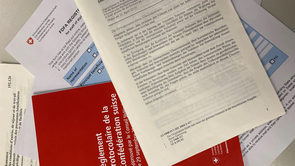 Vari documenti, tra cui la Convenzione di Vienna sulle relazioni consolari, sparsi su una tavola.