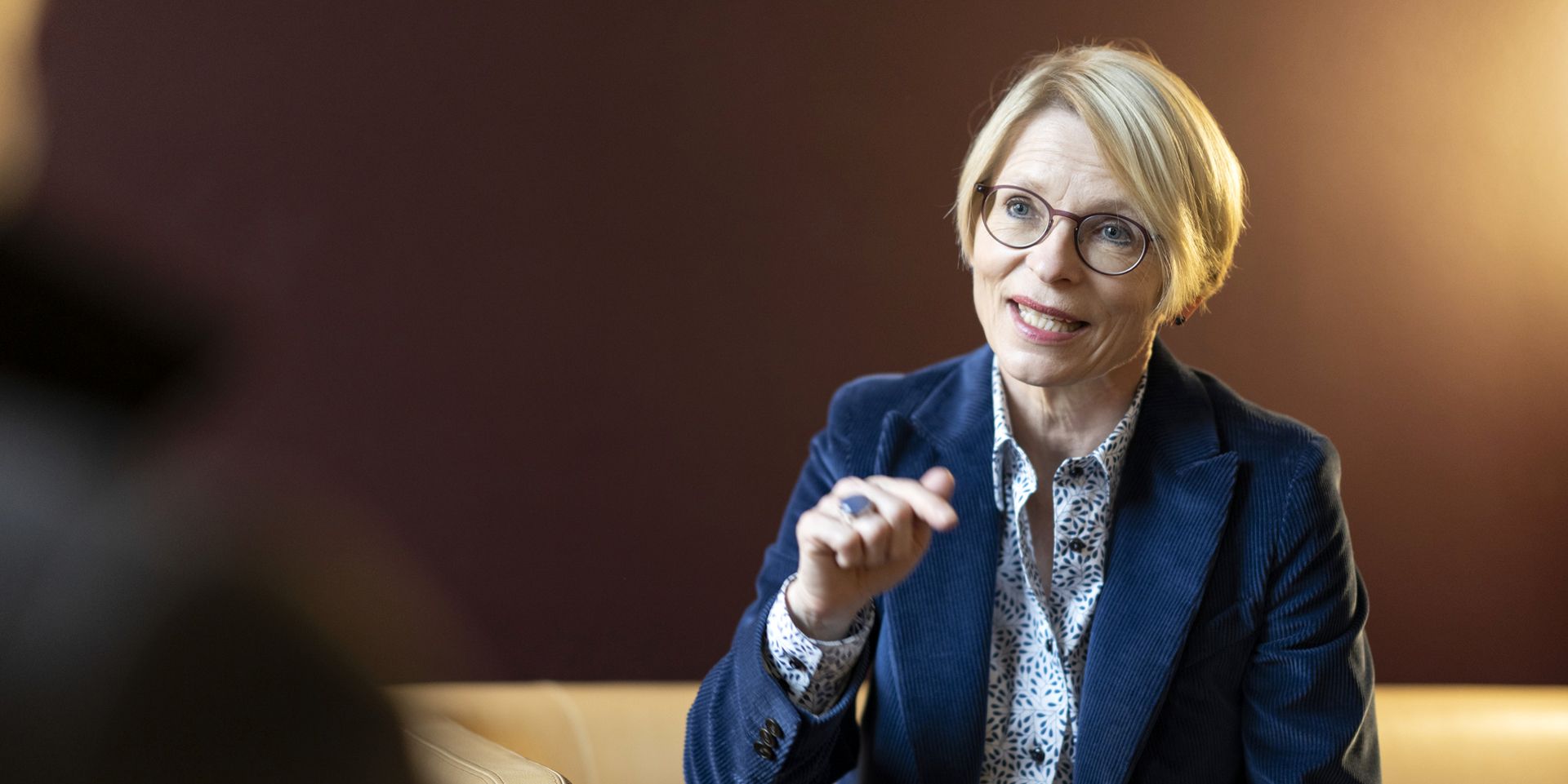 La segretaria di Stato del DFAE parla seduta su un divano di pelle.