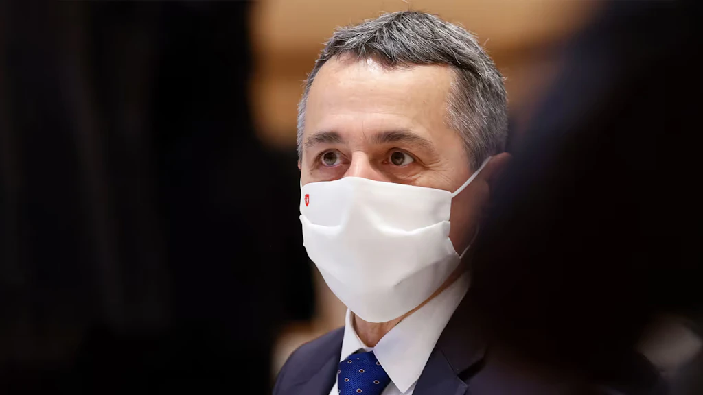 Close-up of Federal Councillor Ignazio Cassis sitting in the room at a UN assembly in November 2020 and wearing a face mask with a Swiss cross.