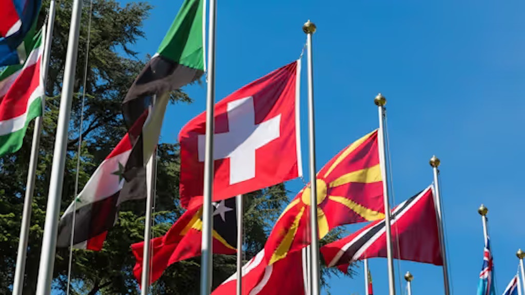 Bandiera svizzera circondata da bandiere di altri Paesi.